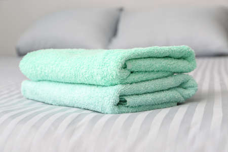 Stack of clean towels on bedの写真素材