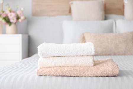 Stack of clean towels on bedの写真素材