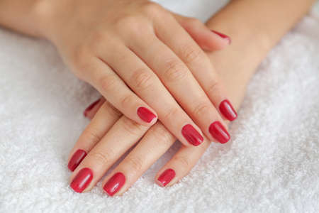 Manicured hands of young woman on towel, closeupの写真素材