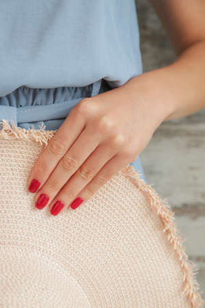 Woman with beautiful manicure holding hat, closeup