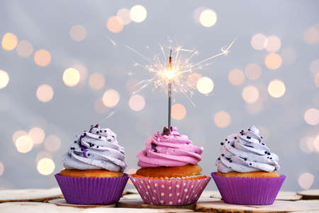 Tasty Birthday cupcakes on table against defocused lightsの写真素材