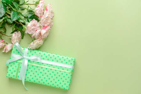 Gift box and beautiful flowers on color backgroundの写真素材