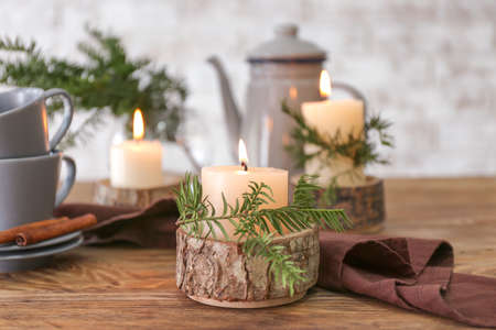 Coffee pot, cups and burning candles on tableの写真素材