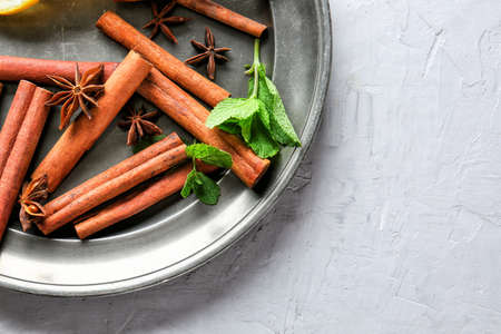 Plate with cinnamon, anise and mint on gray backgroundの写真素材
