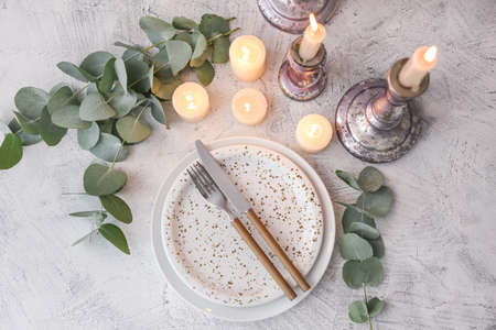 Beautiful table setting with burning candles and floral decor