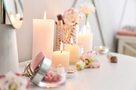 Beautiful burning candles and cosmetics on dressing tableの写真素材