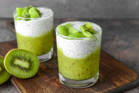 Glasses with tasty kiwi dessert on wooden boardの写真素材
