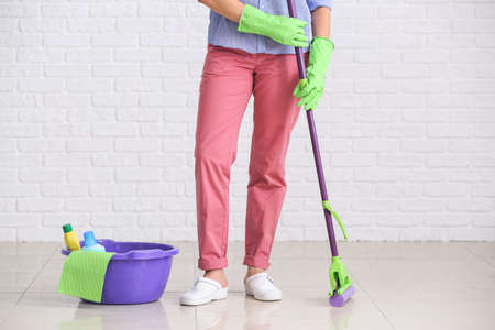 Woman with cleaning supplies in room