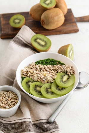 Bowl with tasty oat flakes and kiwi on white tableの写真素材