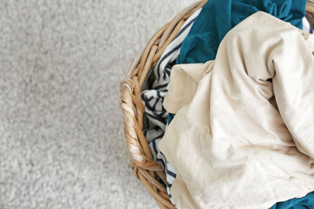 Basket with dirty laundry on floor, closeup