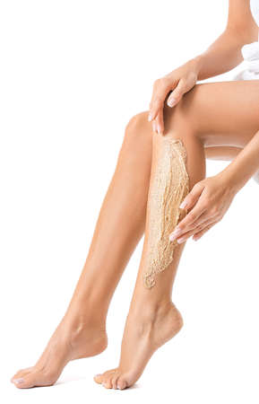 Beautiful young woman applying body scrub against white backgroundの写真素材