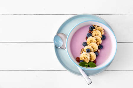 Bowl with tasty blueberry smoothie on white tableの写真素材