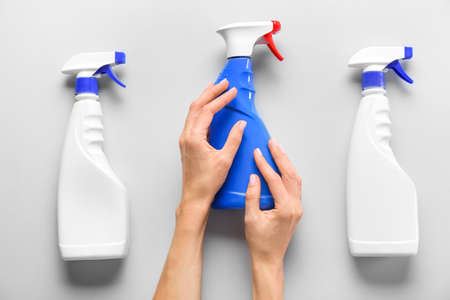 Female hands with bottles of detergent on white backgroundの写真素材