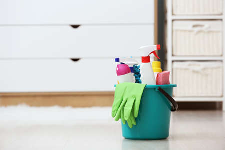 Bucket with cleaning supplies on floor in roomの写真素材