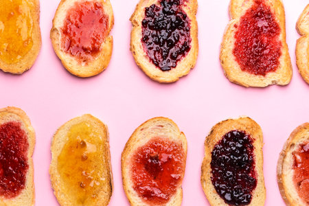 Tasty toasted bread with different jams on color backgroundの写真素材