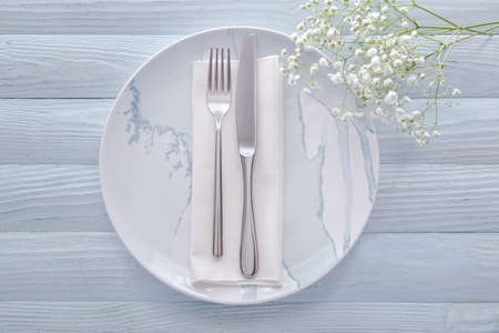 Table setting with flowers on light wooden background