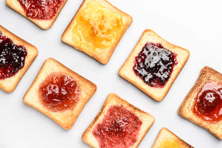 Tasty toasted bread with different jams on white backgroundの写真素材
