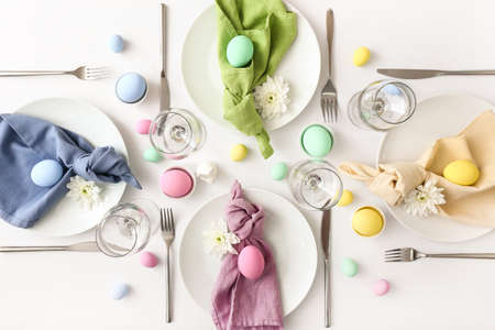 Table setting for Easter celebration on white background