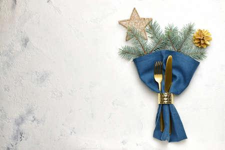 Cutlery and napkin for Christmas table setting on light background