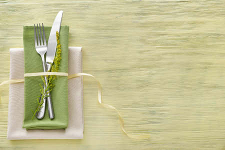 Clean cutlery with napkins on wooden background