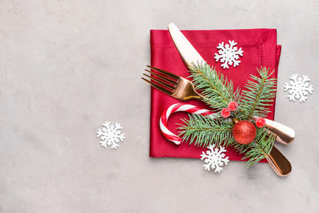 Cutlery and napkin for Christmas table setting on gray background