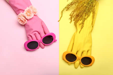 Stylish sunglasses with rubber gloves and flowers on color backgroundの写真素材
