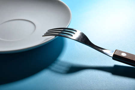 Empty plate with fork on color background, closeupの写真素材