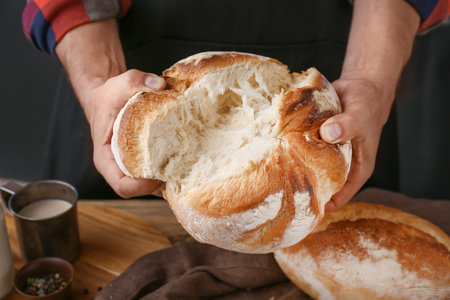 Woman breaking fresh bread, closeupの写真素材