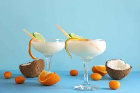 Glasses of tasty Pina Colada cocktail and fruits on color background