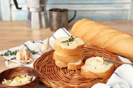 Slices of fresh bread with butter, herbs and garlic on tableの写真素材