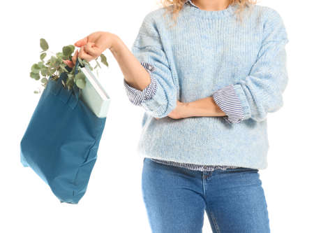 Woman with book and eucalyptus in eco bag on white background, closeupの写真素材