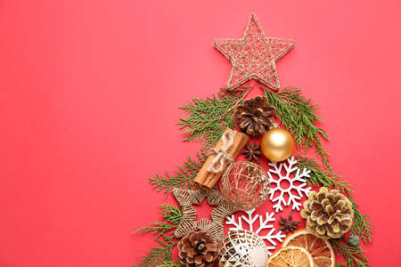 Christmas tree made of branches and decor on color background