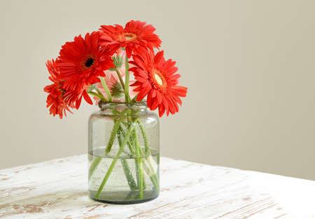 Vase with beautiful gerbera flowers on tableの写真素材