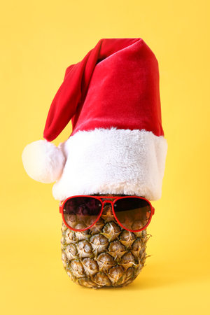 Pineapple with Santa hat and sunglasses on color backgroundの写真素材