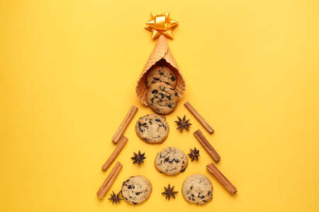 Beautiful composition with Christmas tree made of sweets and spices on color background