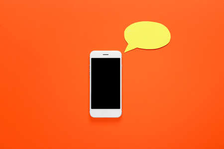 Mobile phone and blank speech bubble on color backgroundの写真素材