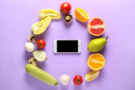 Mobile phone and fresh products on color backgroundの写真素材