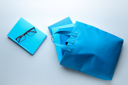 Eco bag with books and eyeglasses on gray backgroundの写真素材