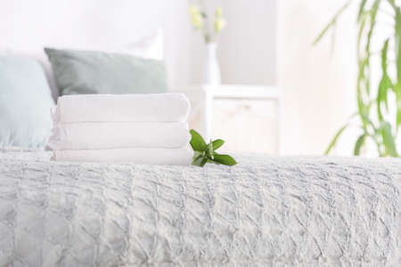 Stack of clean towels on bedの写真素材