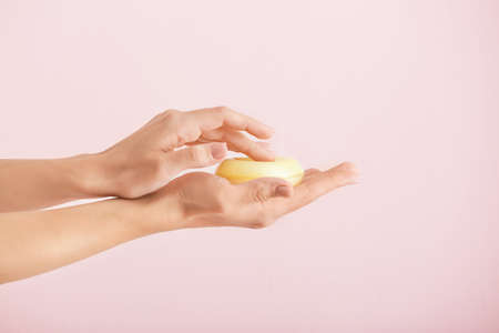 Female hands with soap bar on light backgroundの写真素材