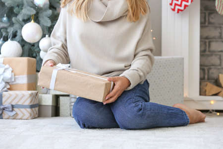 Woman with beautiful Christmas gifts at homeの写真素材