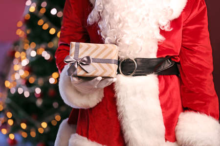 Santa Claus with Christmas gift in room