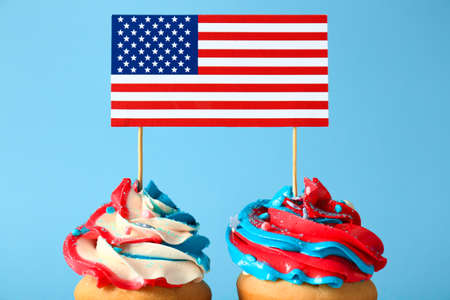 Tasty patriotic cupcakes and USA flag on color backgroundの写真素材