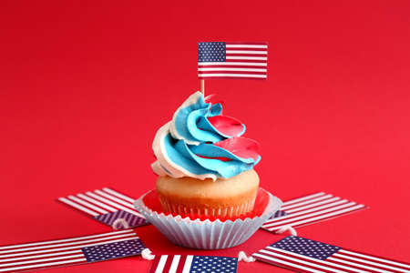Tasty patriotic cupcake and USA flags on color backgroundの写真素材
