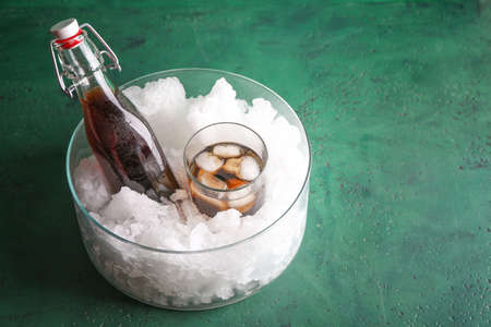 Fresh cola with ice on color backgroundの写真素材