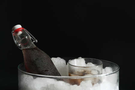 Fresh cola with ice on dark background