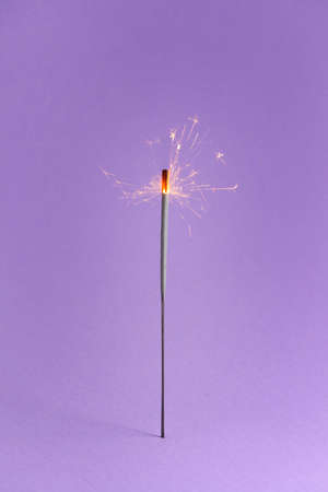 Festive Christmas sparkler on color backgroundの写真素材