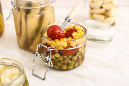 Jar with canned vegetables on light tableの写真素材
