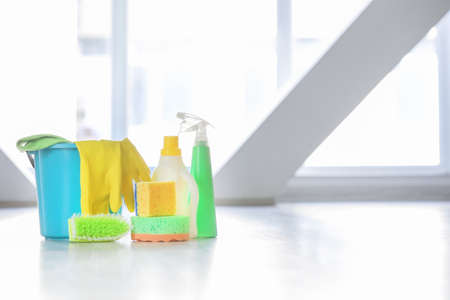 Set of cleaning supplies on floor in roomの写真素材