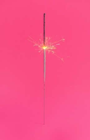 Festive Christmas sparkler on color backgroundの写真素材